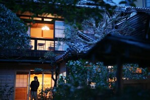 A traditional Japanese building with a wooden exterior and a visible interior with sliding doors and a lantern. - GUESTHOUSE Kinosaki Wakayo - Hostel, Caters to Women (Toyooka)