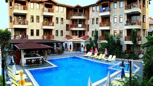 Un hôtel doté d’une piscine, d’un espace extérieur aménagé et de balcons.