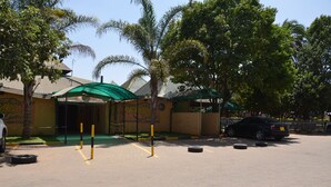 A building with a green awning and a sign that reads "Lodge". - Tents Hotel (Nairobi)