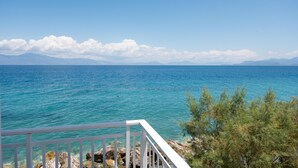 A coastal view with a clear sky, calm sea, and rocky terrain. - Spacious Apartment on the Beachfront (Xylokastro-Evrostina)