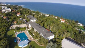 An aerial view of a residential area with a large building, a swimming pool, and a view of the sea. - Strandzha Hotel (Varna)