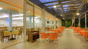 A spacious indoor dining area with tables and chairs, large windows, and a glass ceiling. - Strandzha Hotel (Varna)