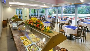 A buffet area with various food options and a floral centerpiece. - Strandzha Hotel (Varna)