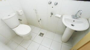 A bathroom with a toilet, sink, and shower. - Hotel Star Park (Chittagong)