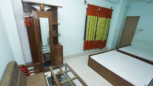 A room with a bed, a sofa, a glass-top table, a wardrobe, and a curtain. - Hotel Star Park (Chittagong)
