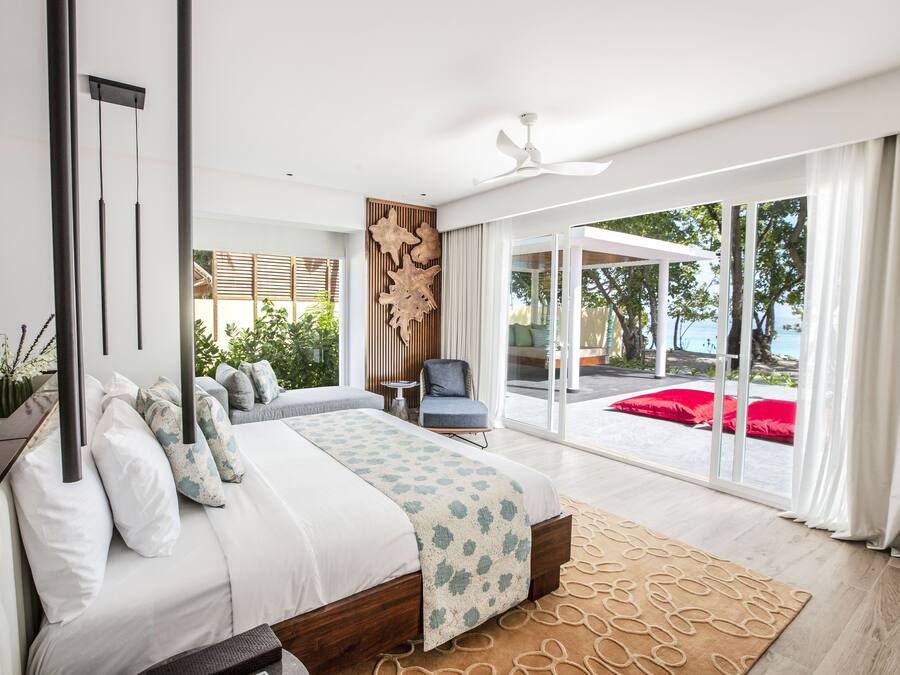 Un dormitorio moderno con una cama grande, un ventilador de techo y vistas al exterior.
