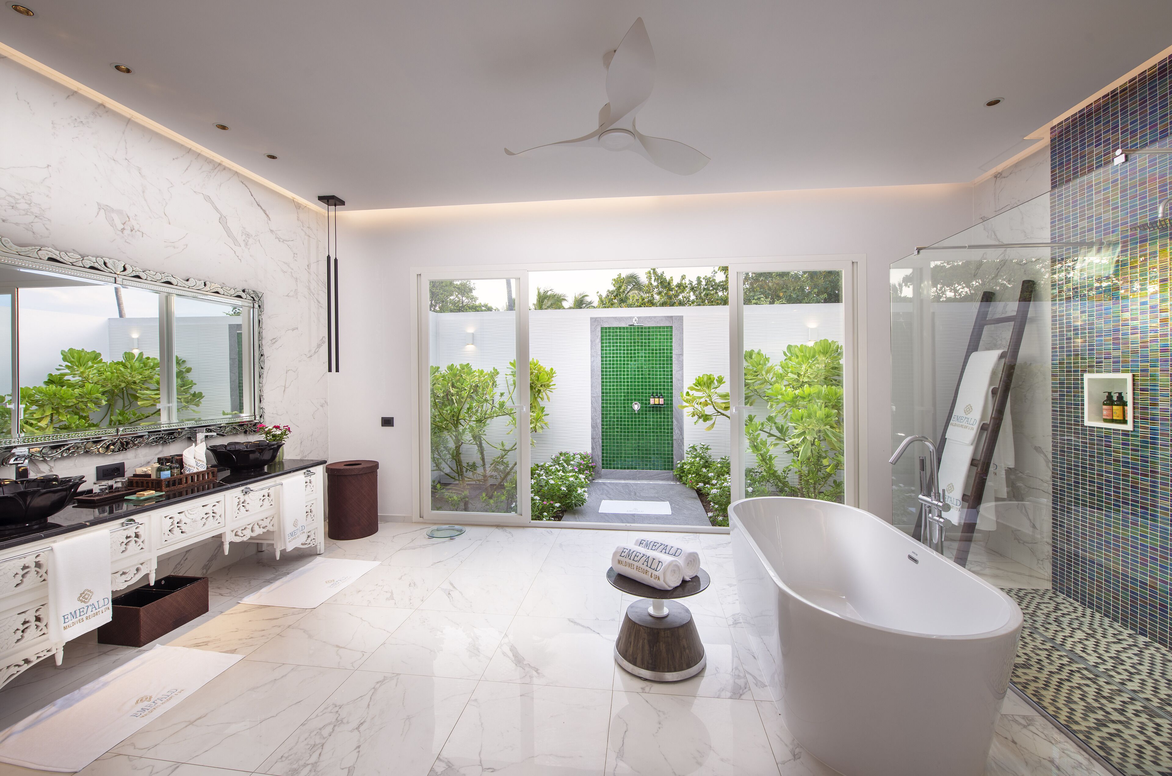 Une salle de bain moderne avec une baignoire sur pieds, un grand miroir et un meuble-lavabo doté de plusieurs vasques.