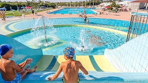 A swimming pool with multiple lanes and a water slide. - 3 bedroom cozy home in Albarella RO (Albarella RO)