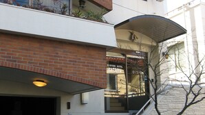 A multi-story building with a business hotel sign, a covered entrance, and a staircase leading to the entrance. - KATSUYA Inn (Wakayama)