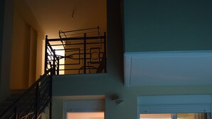 Zona de piscina con una silla y una escalera que lleva al segundo piso.