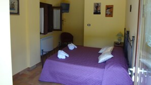 Une pièce comprenant un lit, une chaise, un bureau et un radiateur.
