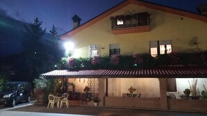 Un bâtiment à deux étages, doté d’un toit en tuiles et d’un balcon orné de plantes en pot.