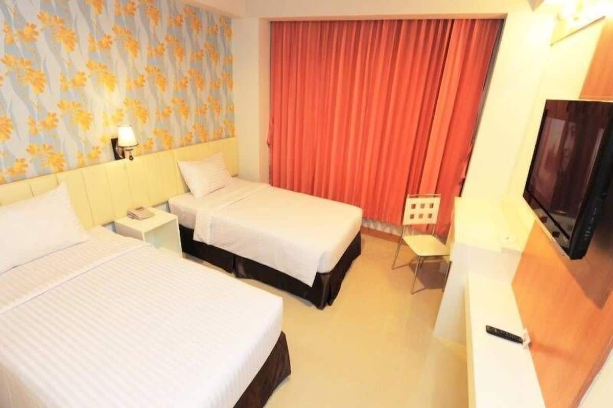 A hotel room with two beds, a TV, a desk, and a chair.