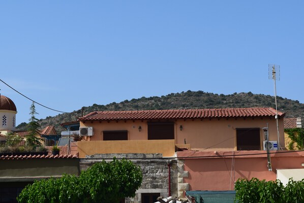 A two-story building with a red-tiled roof, a small balcony, and a satellite dish on the roof. - Venetian Cistern Villa (Apokoronas)