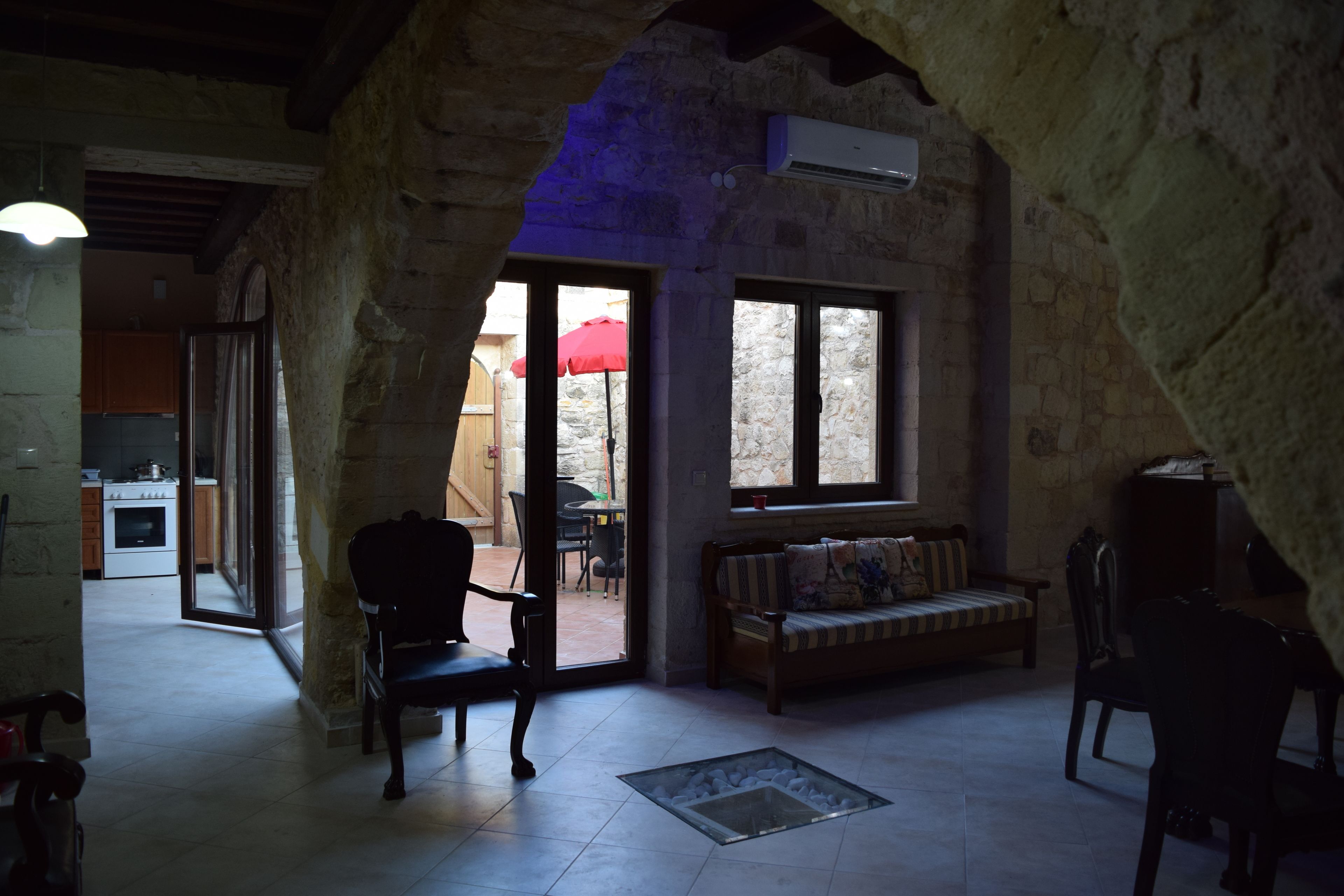 A rustic interior with stone walls, a wooden bench, and a dining table.