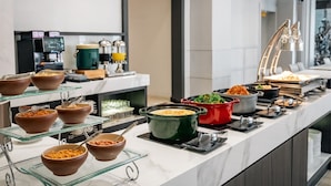 Un buffet con diversi piatti e un angolo caffè.
