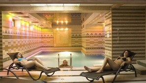 A pool area with lounge chairs and a tiled wall. - Bona Vita Hotel - All Inclusive (Varna)