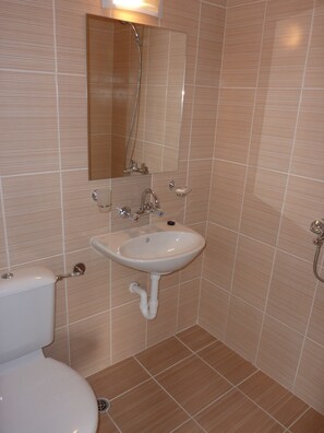 A bathroom with a white sink, a mirror, and a toilet. - Tango (Golden Sands)
