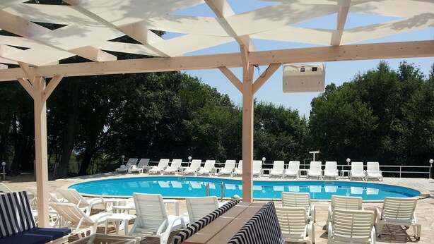 A poolside area with lounge chairs and a wooden deck. - Hotel Zarya- All Inclusive Light (Golden Sands)