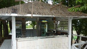 A small outdoor kiosk with a thatched roof, a counter, and a refrigerated display case. - Hotel Zarya- All Inclusive Light (Golden Sands)