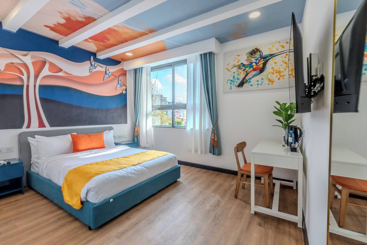 A modern bedroom with a bed, a desk, and a chair.
