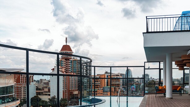 A rooftop pool with a wooden deck and a city view. - Kingfisher Nest Hotel Suites-Westlands, Near Sarit Center (Nairobi)
