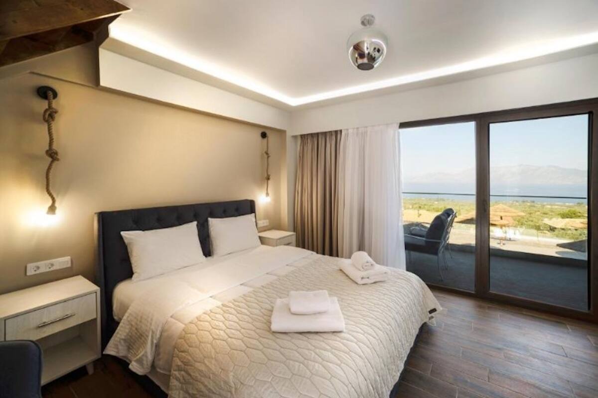 Una habitación de hotel moderna con una cama grande, un escritorio y vistas a la playa.