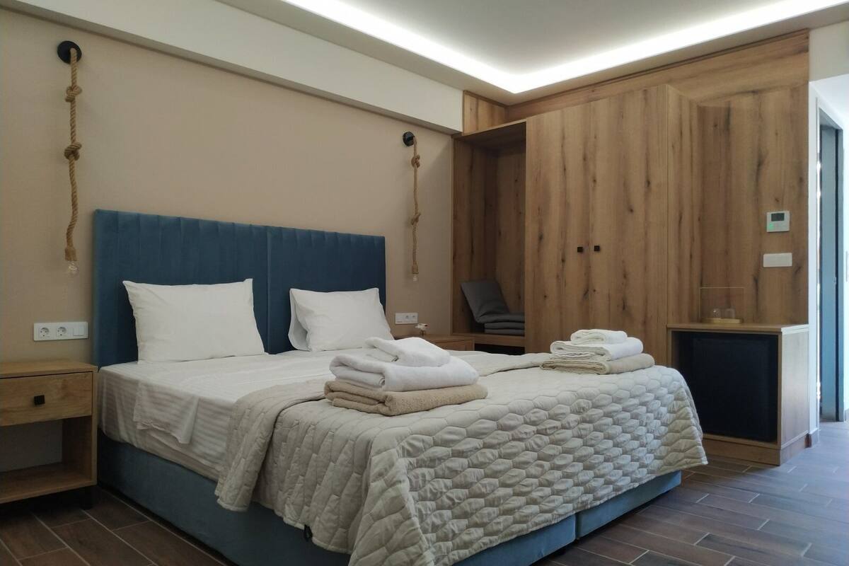 Un dormitorio con una cama grande, un armario de madera y una pequeña zona de estar.