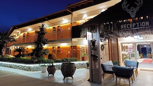 A two-story building with a reception area, outdoor seating, and potted plants. - Anthidon Estate (Chalcis)
