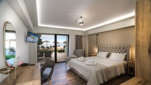 A modern hotel room with a large bed, a desk, a chair, and a TV. - Anthidon Estate (Chalcis)