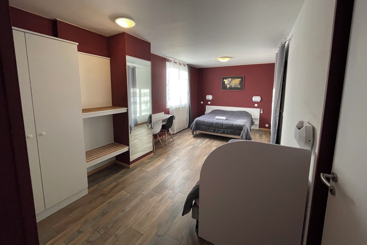 Un dormitorio con cama, escritorio y armario.