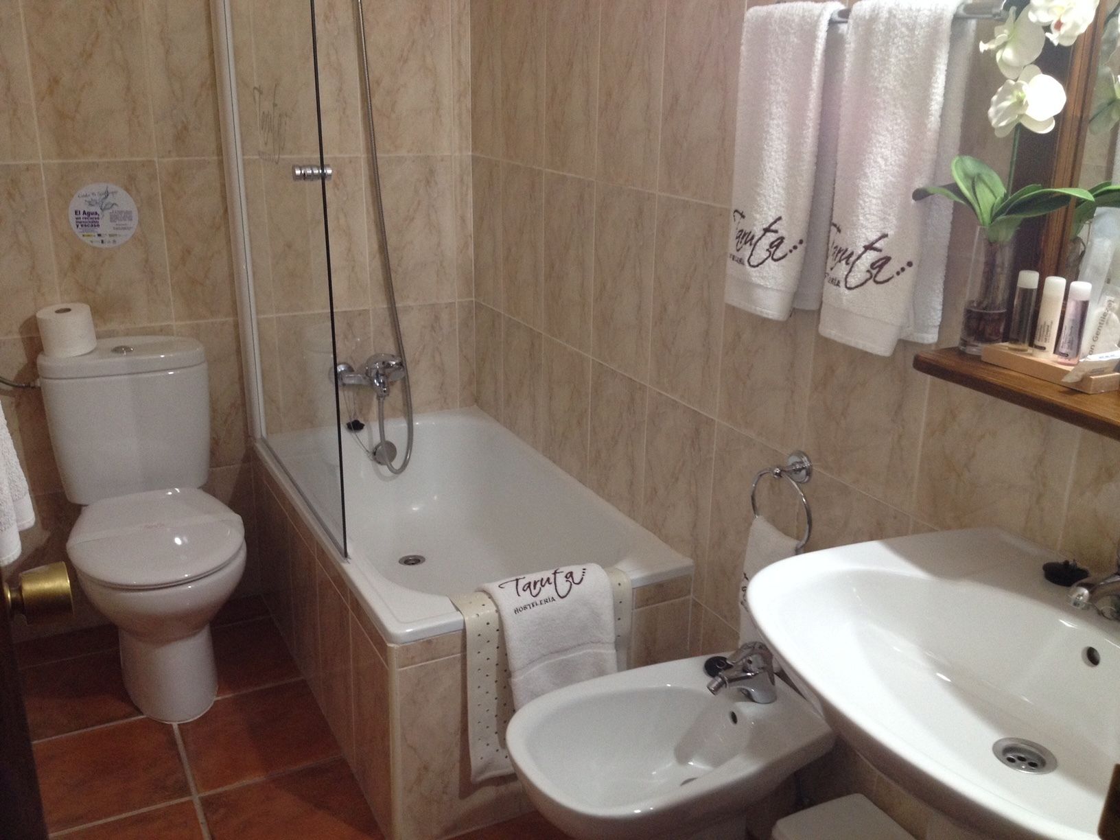 A bathroom with a toilet, a bathtub, a bidet, and a sink.