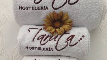 Tres toallas dobladas con bordado de texto y un adorno de girasol.