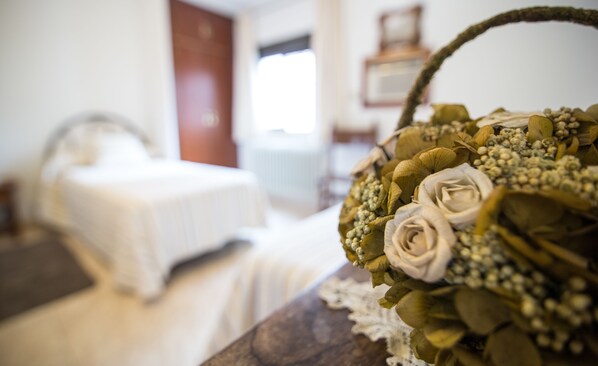 A bed with white bedding in a room with a wooden headboard.