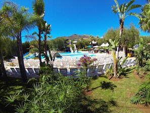 Una piscina al aire libre de temporada, sombrillas