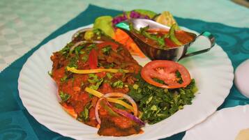A plate of food with a variety of vegetables and a metal cup.