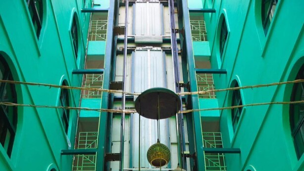 A multi-story building with a central atrium, glass railings, and hanging spherical decorations. - Comfy Inn Eldoret (Eldoret)