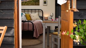 Un dormitorio acogedor con cama, mesita de noche y vista al mar a través de una ventana.