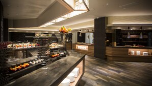 Un dispositiu de buffet modern amb diverses estacions de menjar i un aparador central de fruita.