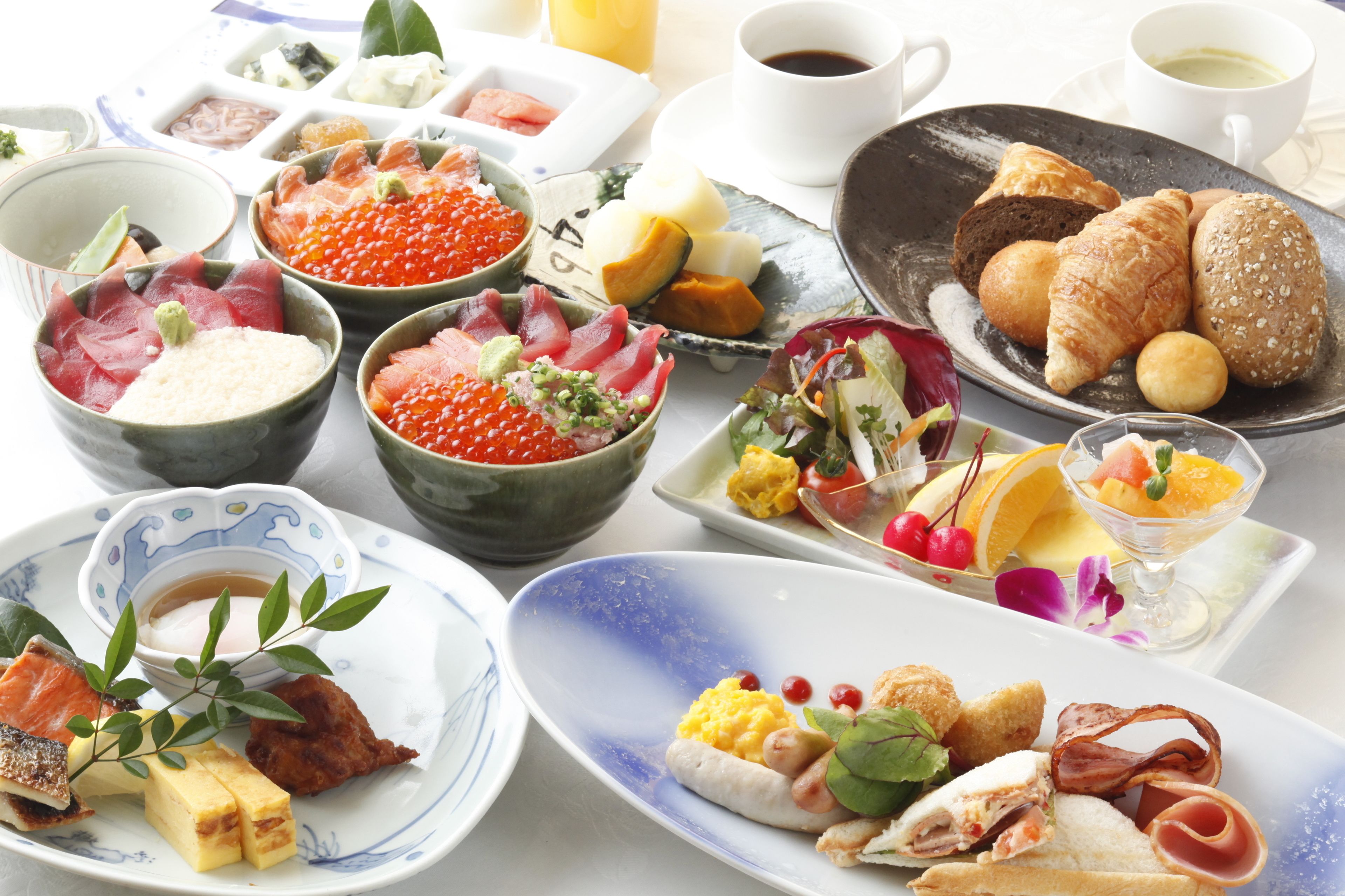 A variety of dishes including sashimi, bread, and a dessert with fruit.