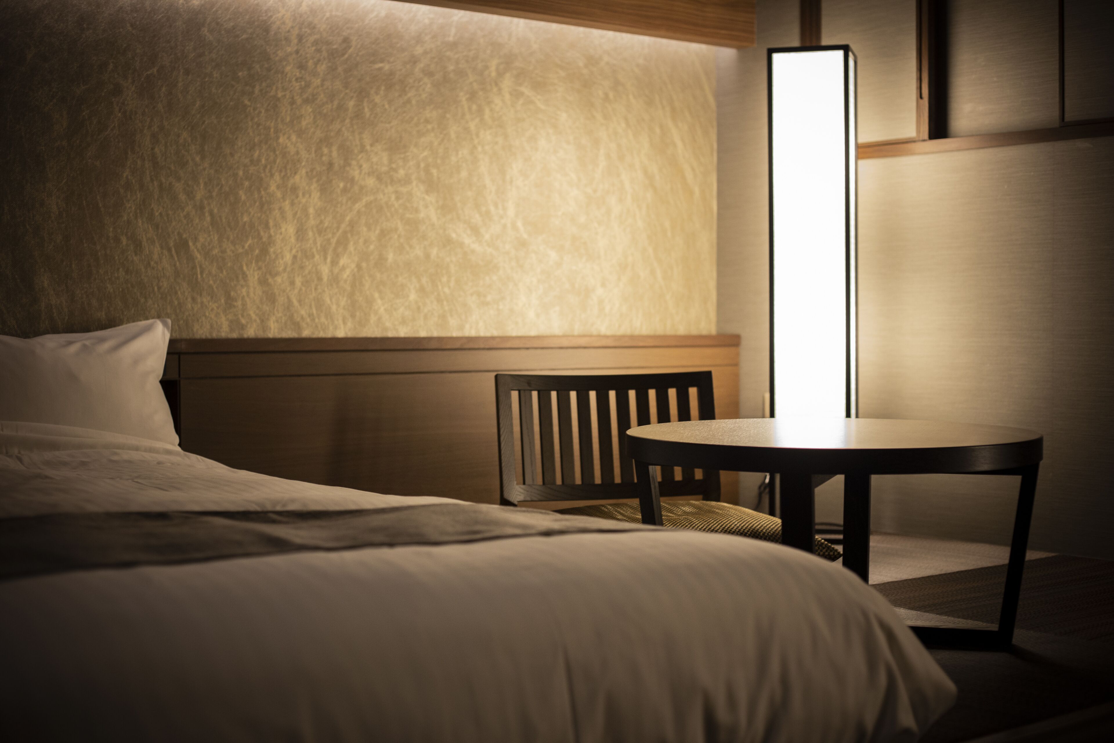 Une chambre d’hôtel avec un lit, une table ronde et une chaise.