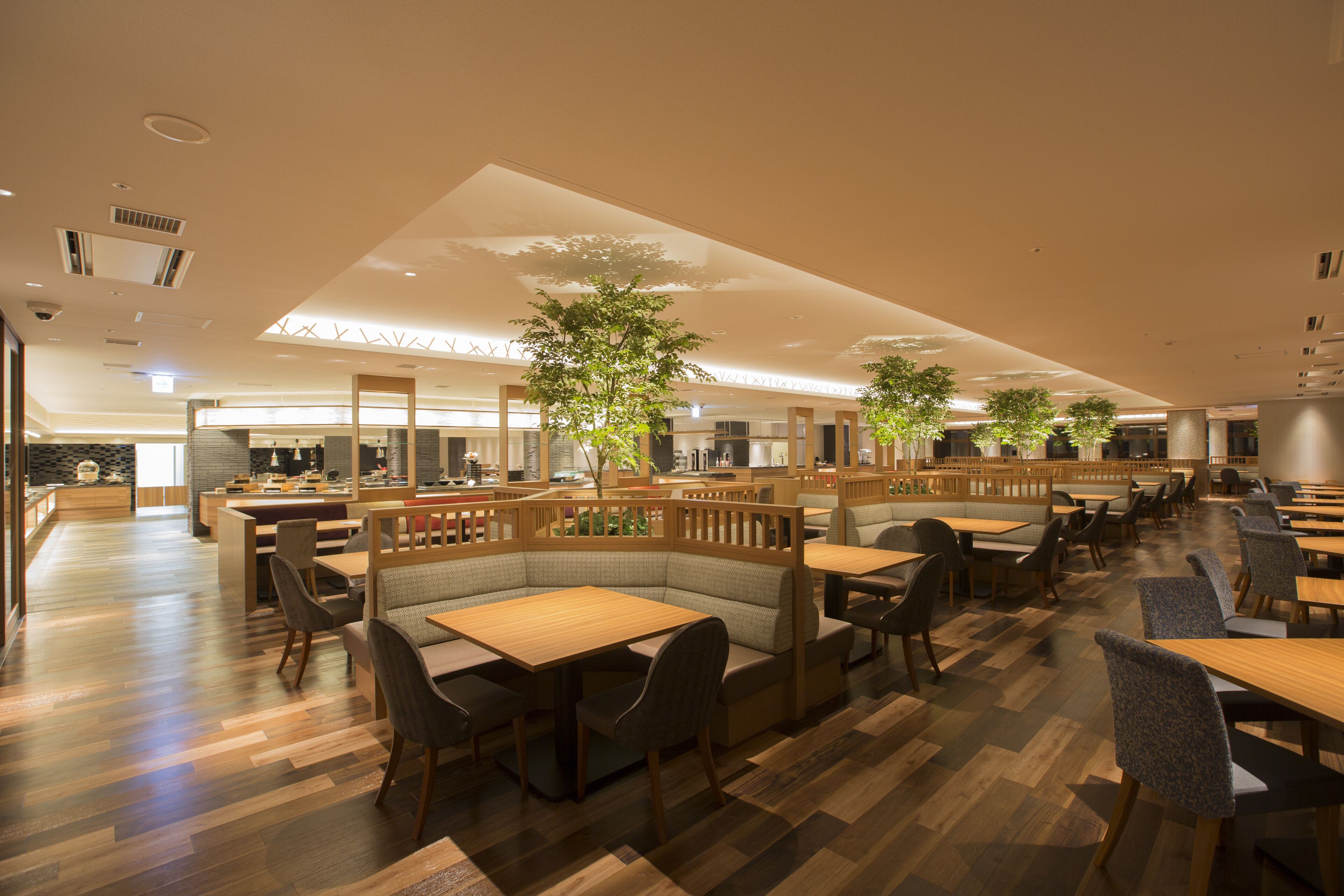 Un restaurante moderno con suelo de madera, cabinas y mesas.