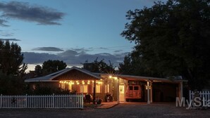 A building with a porch, a covered area, and a vehicle parked in front. - Close to National Parks.The Star Garage, Sleep in a Vintage Truck Bed, Cool! (Kanab)