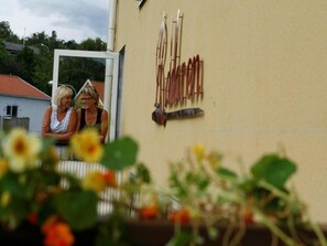 Two people sitting outside a building with a sign that reads "FARMERS". - Roddaren Vandrarhem - Hostel (Stromstad)