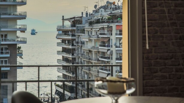 A view from a balcony overlooking a body of water with buildings in the background.
