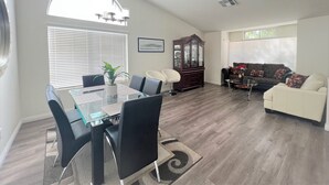A spacious living area with a dining table, chairs, a sofa, and a cabinet. - Spacious New Remodel  Vacation Home (Las Vegas)