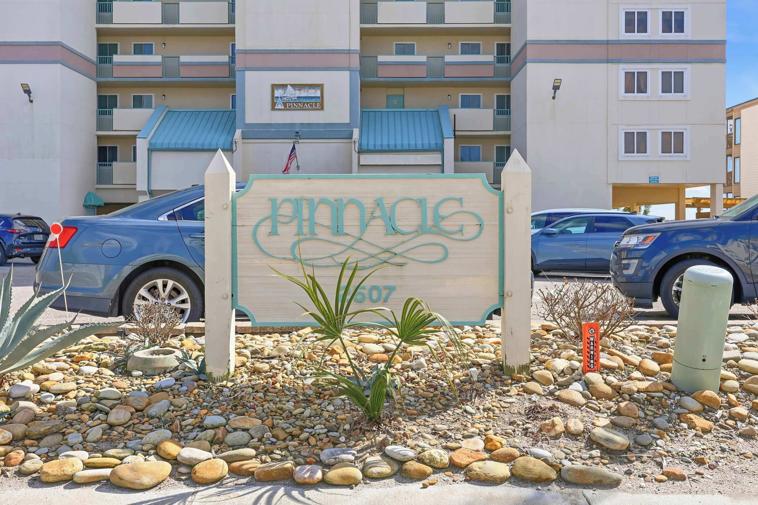 Ein Schild für Pinnacle mit Blick auf ein mehrstöckiges Gebäude im Hintergrund.