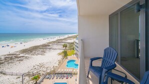 Un balcon avec vue sur une plage et une piscine.