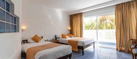 A hotel room with two beds, a balcony with curtains, and a view of palm trees.