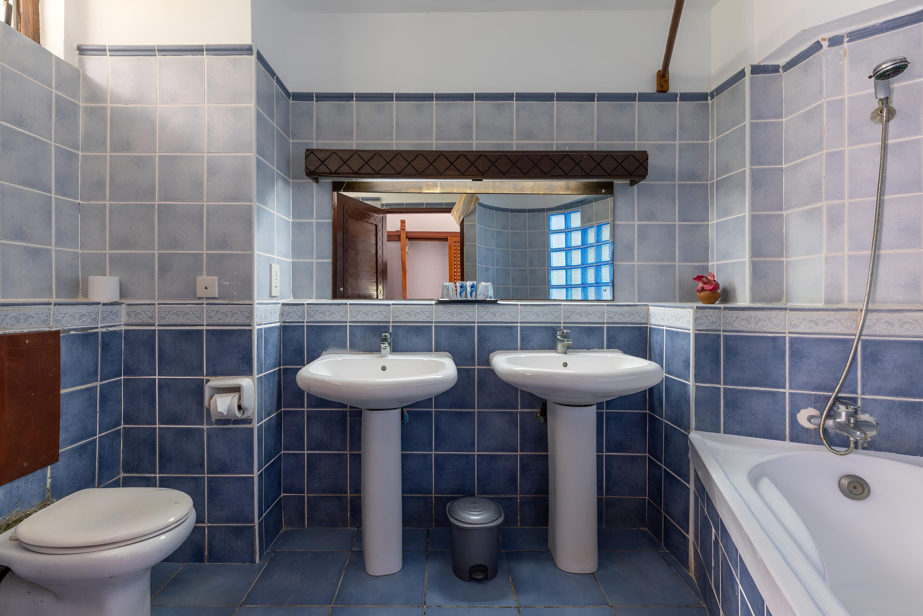 A bathroom with two sinks, a toilet, and a bathtub.